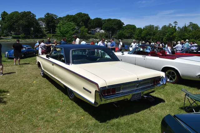 Rear three-quarter view showing the hardtop roof, glass, damascened tail panel, lamps, bumper, quarter trim, and wheel covers.