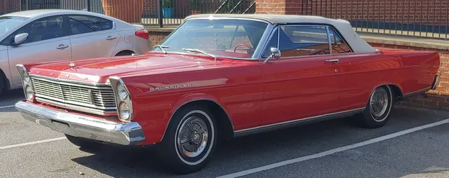Red Galaxie 500 convertible with raised top, front three-quarter view