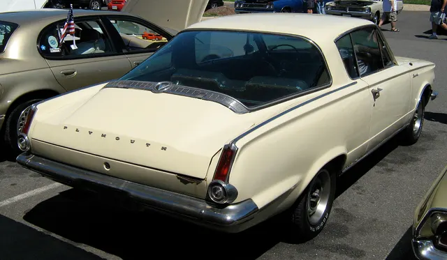 Exact-year rear three-quarter view retained for wraparound glass, deck, lamps, bumper, and body context; visible wear and nonstock wheels are specific to the photographed car.