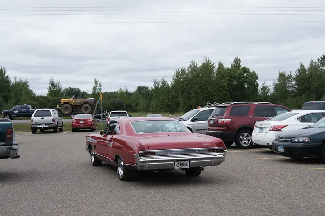 Red 1965 2+2 rear view showing the full-size hardtop stance