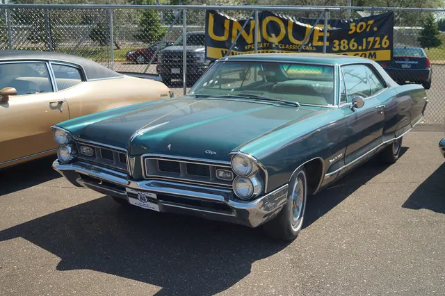 Green 1965 Pontiac Grand Prix showing the formal hardtop roofline
