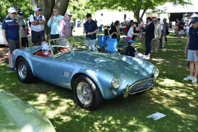 Side and front three-quarter view of the restored 289 showing the compact Mk II roadster profile, side vent, wire wheels, and weather-equipment mounting context.