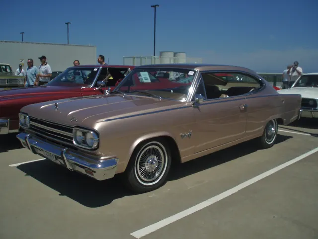 Front three-quarter view of a stock-presenting exact-year car showing the grille, quad headlamps, hood ornament and script, fender emblems, bright side trim, fastback roof, and factory-style wire covers.