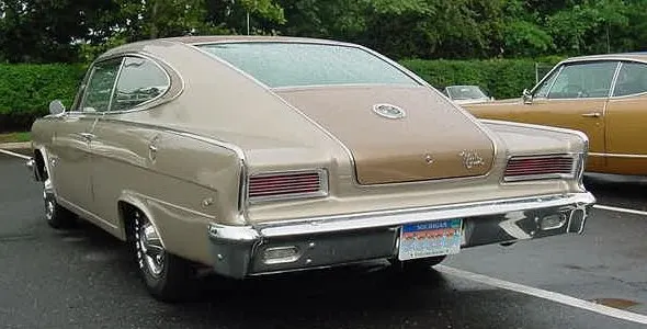 Rear three-quarter view showing the curved fastback glass, deck medallion, Marlin script, tunneled tail lamps, bumper, and two-tone finish boundaries.