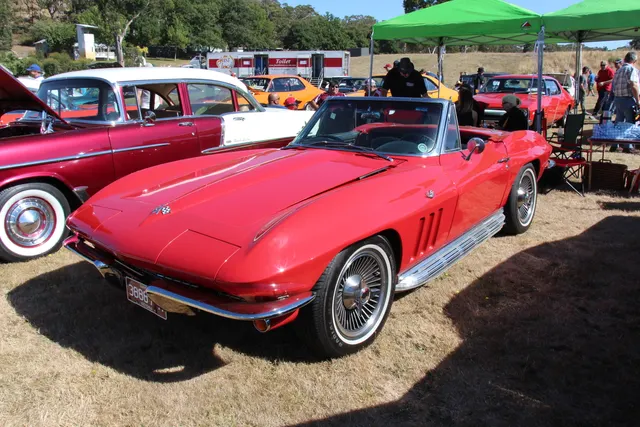 Rally Red 1966 convertible with its soft top lowered, preserving the second factory body style on the canonical model-year page.