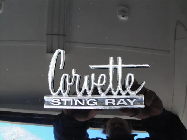 Close view of 1966 Corvette and Sting Ray exterior script during restoration documentation.