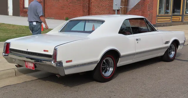 Exact-year 4-4-2 rear view retained for the tail lamps, Oldsmobile panel lettering, 4-4-2 badge, brightwork, vinyl roof, and finish; visible trim does not establish L69 equipment.