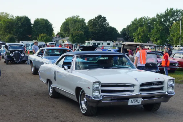 White 1966 2+2 hardtop approaching at a show