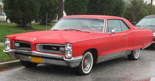 Red 1966 Pontiac Grand Prix with factory-style wheel covers