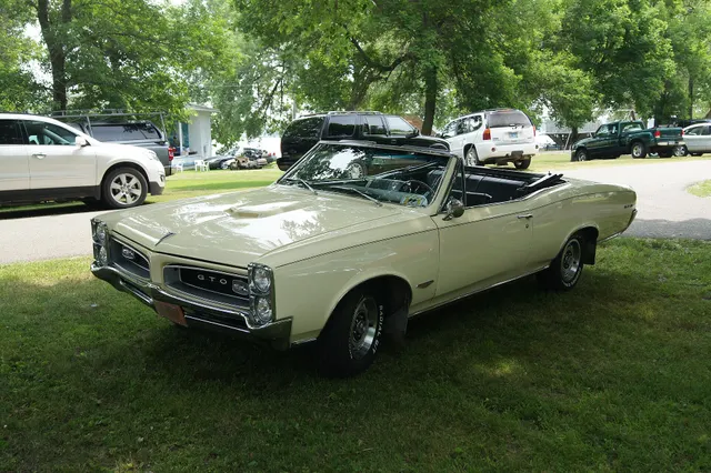 1966 Pontiac GTO convertible front three-quarter view; used for hood-scoop, grille, paint, and body context, not proof of the engine under the hood.
