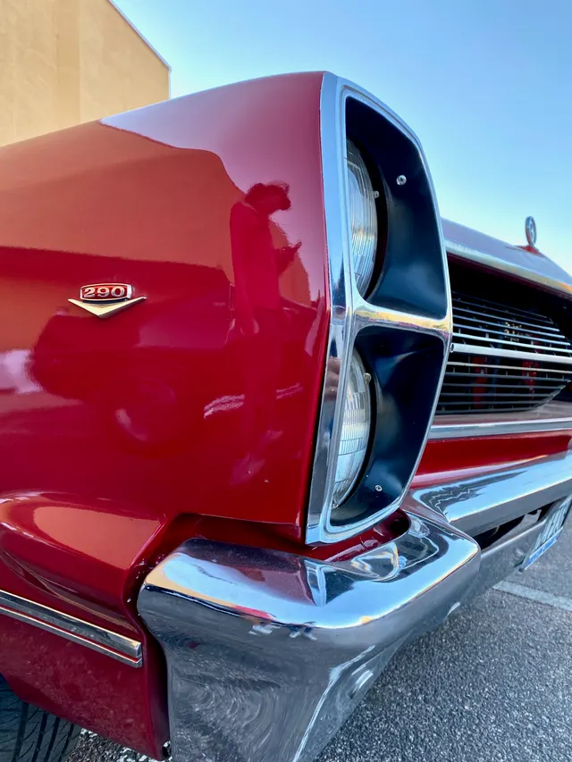 Exact-year 290 fender-emblem and stacked-headlamp detail documenting removable engine identification, grille, bumper, and front trim. The emblem alone does not prove the installed engine.
