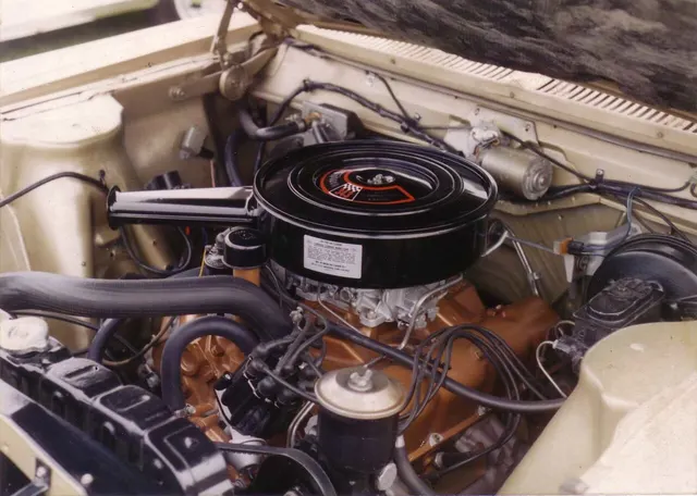 Restored exact-year 343 four-barrel engine bay showing the Typhoon V8 installation, air cleaner and induction, ignition, cooling layout, power brake hardware, shock towers, and braces. Finishes and service parts remain subject-specific.