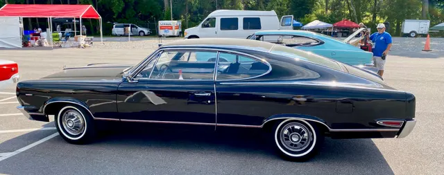 Full side profile of an exact-year black Marlin showing the 118-inch-wheelbase proportions, pillarless opening, long fastback roof, side glass, body trim, factory-style covers, and rear-quarter treatment.