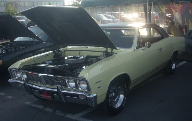 Exact-year regular coupe front view showing the split grille, quad headlamps, bumper, hood, windshield, hardtop opening, and model-year identification.