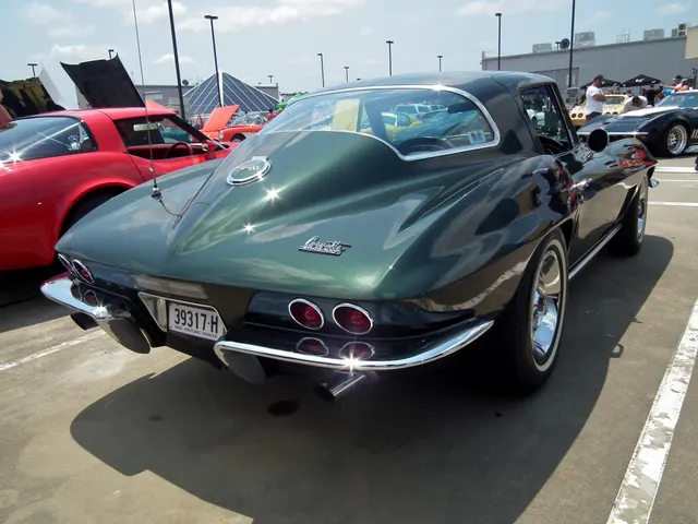 Rear three-quarter view of the green coupe, documenting four taillamps, split bumpers, fastback glass, and the single backup lamp above the license opening.