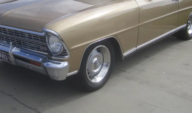 Crop showing 1967 Nova SS grille, lower side molding, and wheel-cover context.