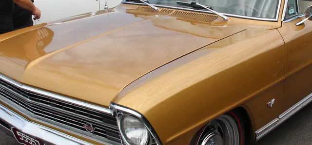 Crop showing 1967 Nova SS front quarter, side molding, emblem, and wheel-cover context.