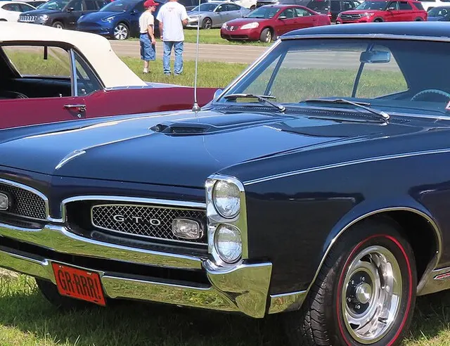 1967 Pontiac GTO front grille and stacked-headlamp detail; local crop from approved Commons media for component and trim context only.