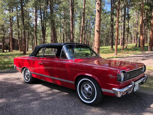The same exact-year Rogue convertible from a distinct side angle, retained for body proportions, convertible top, lower side moldings, Rogue script, wheel covers, whitewalls, and stock stance.