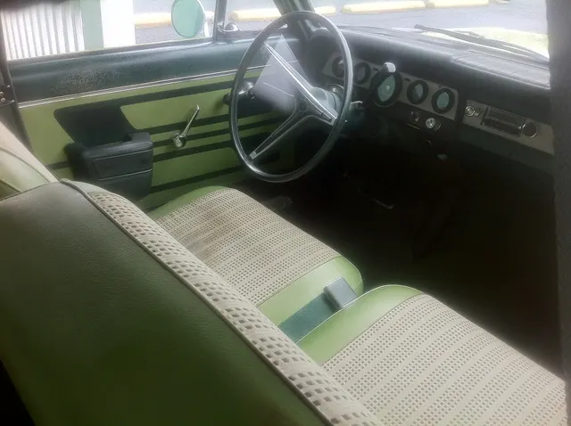 Exact-year 440 driver's area retained for the reclining front seat, door trim, steering wheel, dashboard, column selector, pedals, and Laurel Green cabin context.