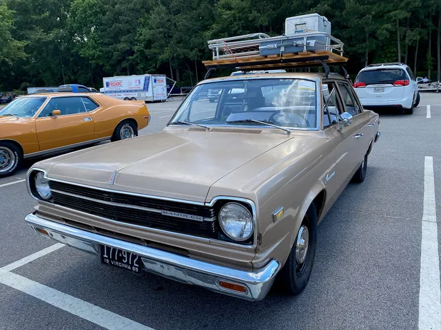 Front three-quarter view of the same base sedan retained for the 1968 grille bar and blackout sections, lamps, hood, windshield, doors, wheel covers, and Laredo Tan finish context.