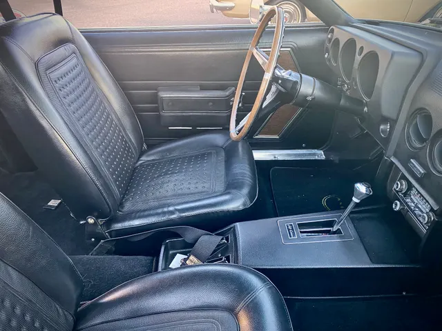 1968 AMC AMX interior with bucket seat, woodgrain dash, console, and Shift-Command shifter context.