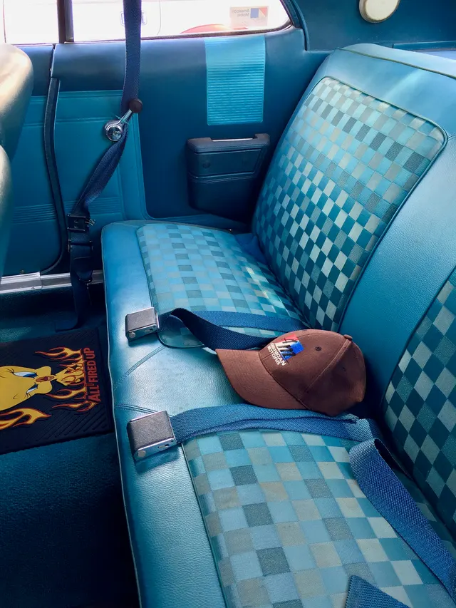 Rear-seat and quarter-trim view from the same 770 hardtop retained for upholstery pattern, side panel, armrest, ashtray, belt, glass, and pillarless-body context; current mats and loose accessories are not factory evidence.