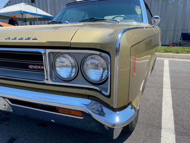 Exact-year Rebel SST convertible close view retained for Scarab Gold paint, SST grille badge, quad lamps, bumper, side marker, and brightwork context; these visible details do not prove another car's trim or drivetrain.