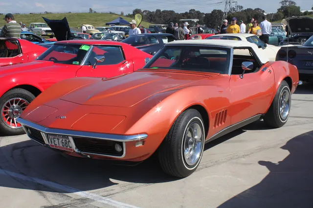Corvette Bronze convertible in front three-quarter view with auxiliary hardtop, white-line tires, and Rally wheels.