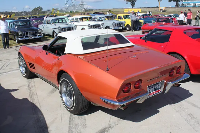 Rear three-quarter view of the Corvette Bronze convertible with auxiliary hardtop, documenting the deck, antenna, taillamps, bumpers, and exhaust exits.