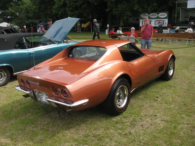 Rear three-quarter view of the coupe showing its removable rear window, four taillamps, split bumpers, fuel door, and sloping rear deck.