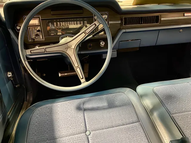 Same-car exact-year Rebel SST cockpit showing the dashboard, steering wheel, controls, and patterned front upholstery.