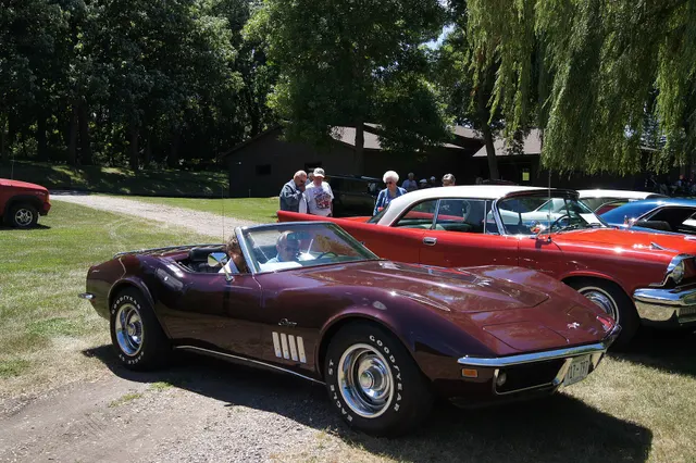 Burgundy roadster front view showing the 1969 nose, concealed lamps, fender gills, windshield, and cabin opening.