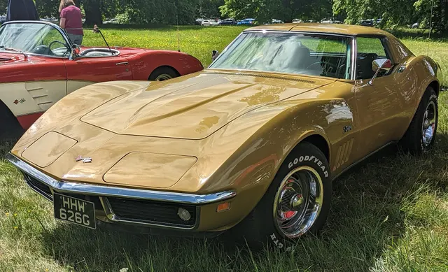 Riverside Gold coupe front three-quarter view showing the C3 profile, roof panels, concealed lamps, chrome bumpers, and Rally wheels.
