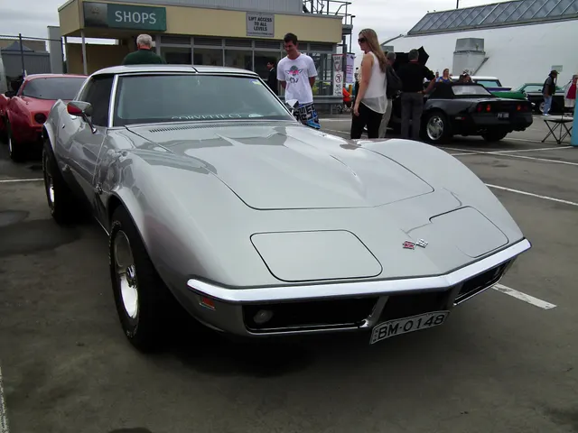 Silver coupe front three-quarter view showing the low nose, concealed headlamps, fender gills, roof panels, and Rally wheels.
