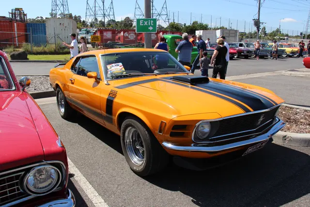 832 made in Grabber Orange. 
The 1970 Mustang was a facelift of the 69, the headlights were moved inside the grille and imitation vents added to the outside where the 69 headlights were, the rear fender scoops were also 