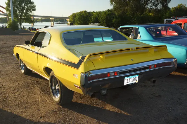 1970 Buick GSX in Saturn Yellow from the rear, showing the spoiler and stripe treatment without asserting drivetrain originality