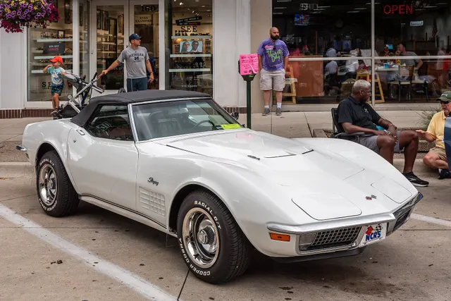 Stock-presenting restored white 1970 Corvette convertible with its soft top raised, showing the open-body profile and standard-era trim.