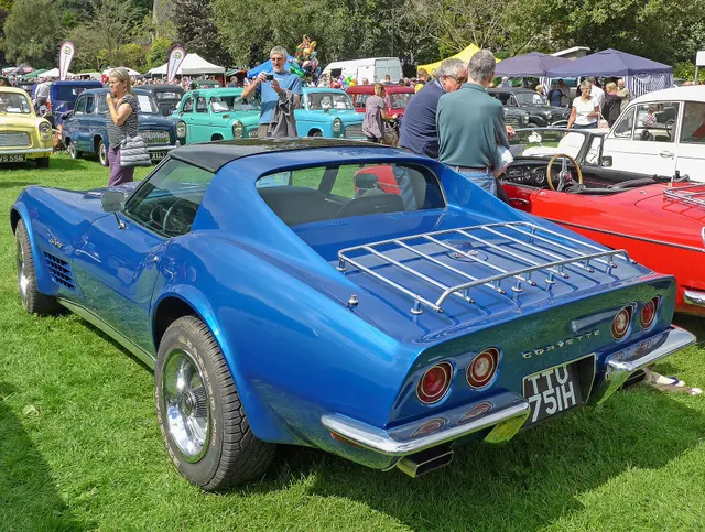 Restored blue 1970 Corvette coupe in rear three-quarter view, showing the removable-roof body, tail treatment, and period touring accessories.