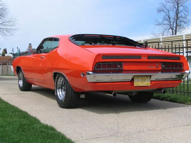 Orange restored/modified 1970 Ford Torino Cobra SportsRoof rear view showing the model-line tail treatment