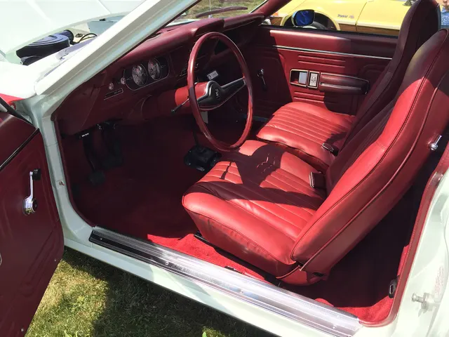 Exact-year four-passenger cabin retained for front seating, upholstery, instrument panel, deep-dish steering wheel, manual floor shift, door trim, pedals, and controls; the pictured custom equipment is car-specific.