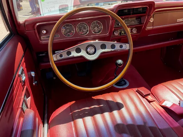 Driver controls with custom rim-blow steering wheel, tachometer, and Hurst-pattern four-speed shifter
