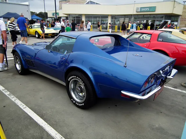 Opposite-side view of the blue coupe, retained for body and trim context; the luggage rack and later tires are not factory-installation evidence.