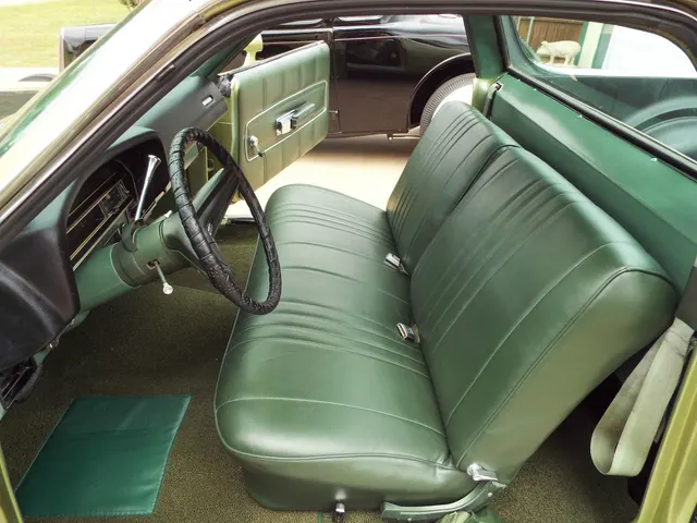 Stock-presenting 1971 Ford Ranchero bench-seat cabin showing the upholstery, dashboard, steering wheel, door panel, and controls of this photographed example.