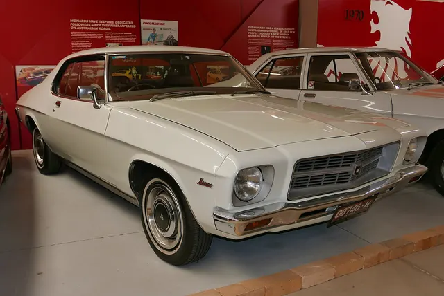 Stock-presenting HQ regular Monaro in the National Holden Motor Museum showing the single-headlamp nose, restrained grille, regular trim, coupe roof, and factory-style wheel covers.