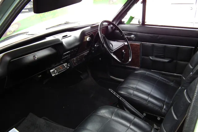 1971 Holden LC Torana 2600 SL cabin showing the right-hand-drive dashboard, steering wheel, front seating, door trim, floor selector, and photographed-car radio.