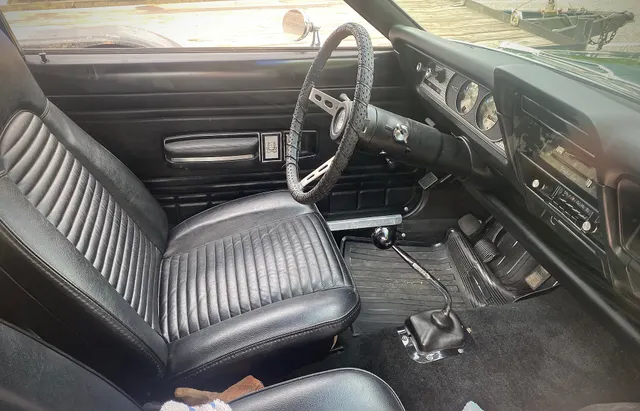 Exact-year Gremlin X cabin retained for pleated-vinyl buckets, door trim, instrument panel, steering wheel, manual floor shift, pedals, and controls; restored upholstery and individual equipment remain car-specific.