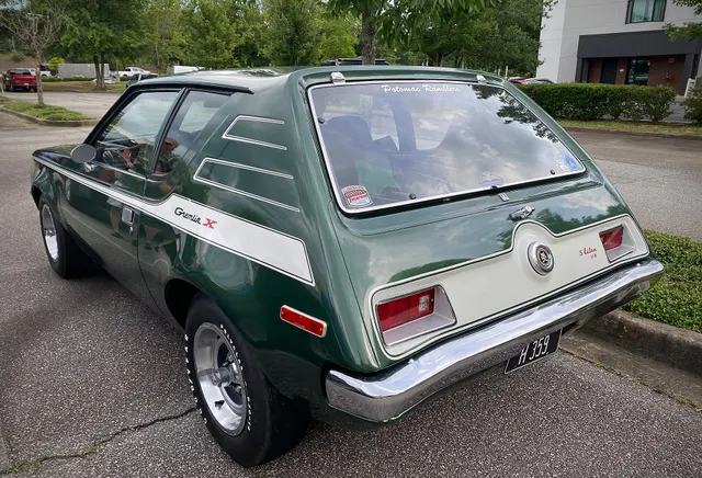 Exact-year Gremlin X rear-quarter view retained for lift-up glass, hinges, rear panel, lamps, fuel filler, bumper, stripe treatment, and V8 emblem context; emblems and stripes alone do not authenticate the package or drivetrain.