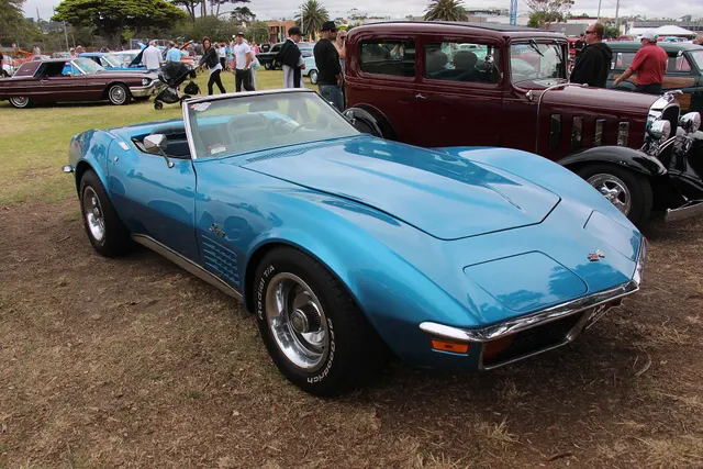 Blue convertible front three-quarter view showing the final-year chrome-bumper C3 profile and black soft top.