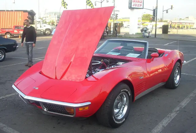 Red convertible with the hood raised, retained for body, hood, and restoration context; visible equipment does not authenticate a drivetrain.